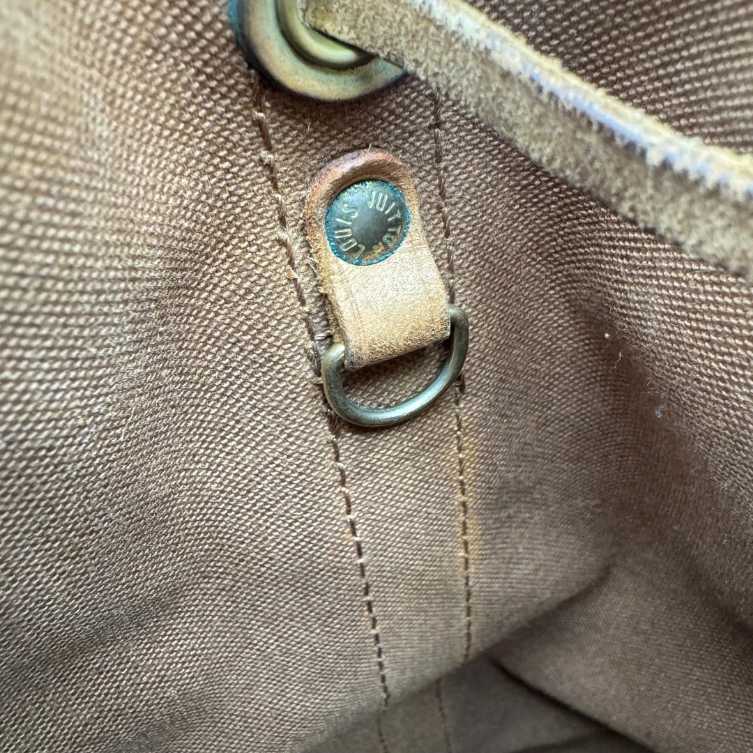 https://cdn.shopify.com/s/files/1/0564/9376/8855/files/Louis_Vuitton_Schultertasche_Sac_Noe_grande_monogram_braun_vintage_LV2214.webp?v=1779962922