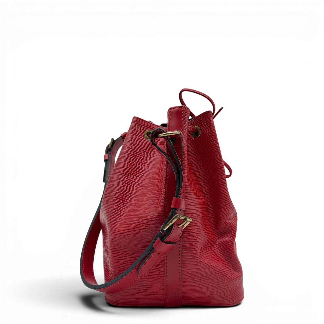 https://cdn.shopify.com/s/files/1/0564/9376/8855/files/Louis_Vuitton_Schultertasche_Sac_Noe_petit_Epi_aus_Leder_rot_vintage_LV6516.webp?v=1778681400