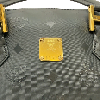 https://cdn.shopify.com/s/files/1/0564/9376/8855/files/MCM_Handtasche_Boston_25_PVC_mit_Umhangegurt_schwarz_12.webp?v=1782983949
