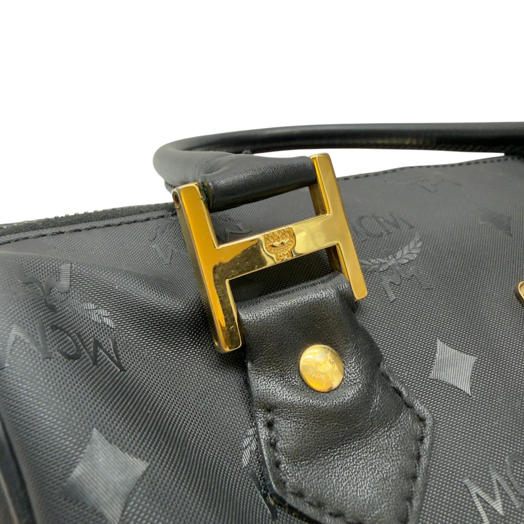 https://cdn.shopify.com/s/files/1/0564/9376/8855/files/MCM_Handtasche_Boston_25_PVC_mit_Umhangegurt_schwarz_13.webp?v=1782983949