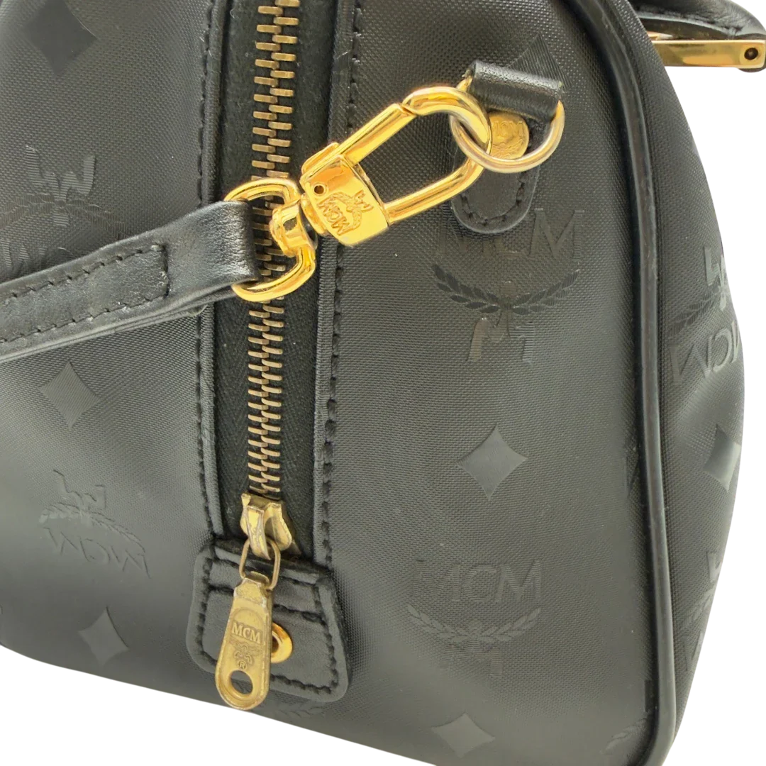 https://cdn.shopify.com/s/files/1/0564/9376/8855/files/MCM_Handtasche_Boston_25_PVC_mit_Umhangegurt_schwarz_14.webp?v=1782983949