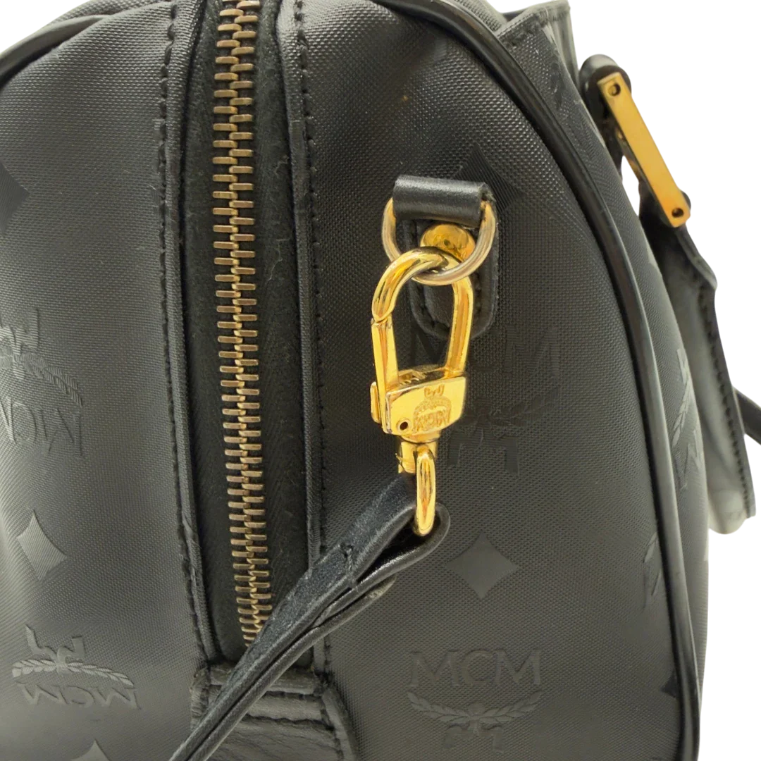 https://cdn.shopify.com/s/files/1/0564/9376/8855/files/MCM_Handtasche_Boston_25_PVC_mit_Umhangegurt_schwarz_15.webp?v=1782983949