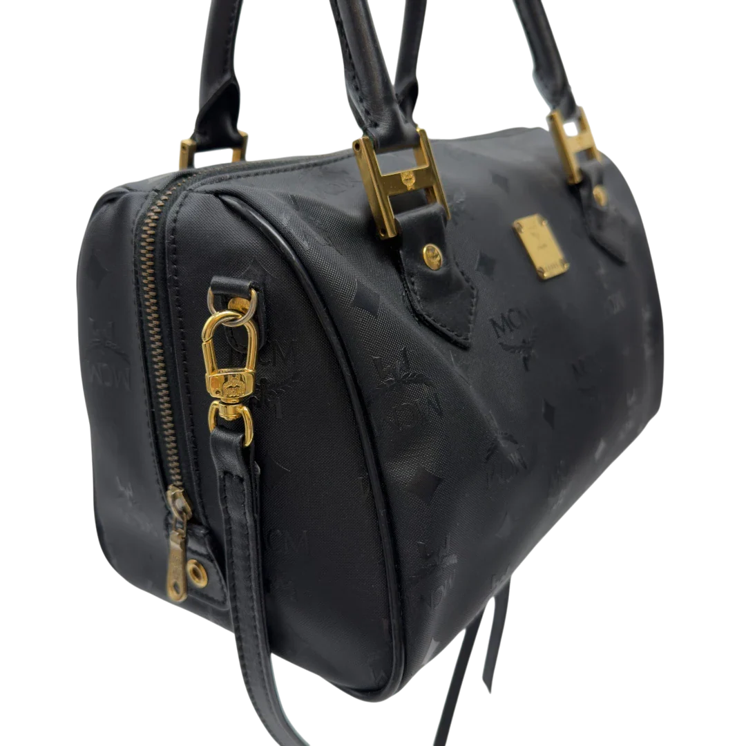 https://cdn.shopify.com/s/files/1/0564/9376/8855/files/MCM_Handtasche_Boston_25_PVC_mit_Umhangegurt_schwarz_18.webp?v=1782983948