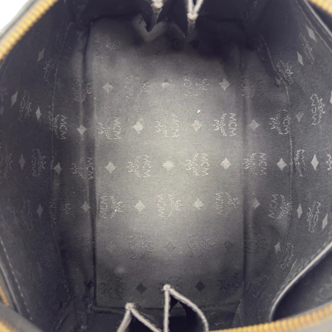https://cdn.shopify.com/s/files/1/0564/9376/8855/files/MCM_Handtasche_Boston_25_PVC_mit_Umhangegurt_schwarz_19.webp?v=1782983949