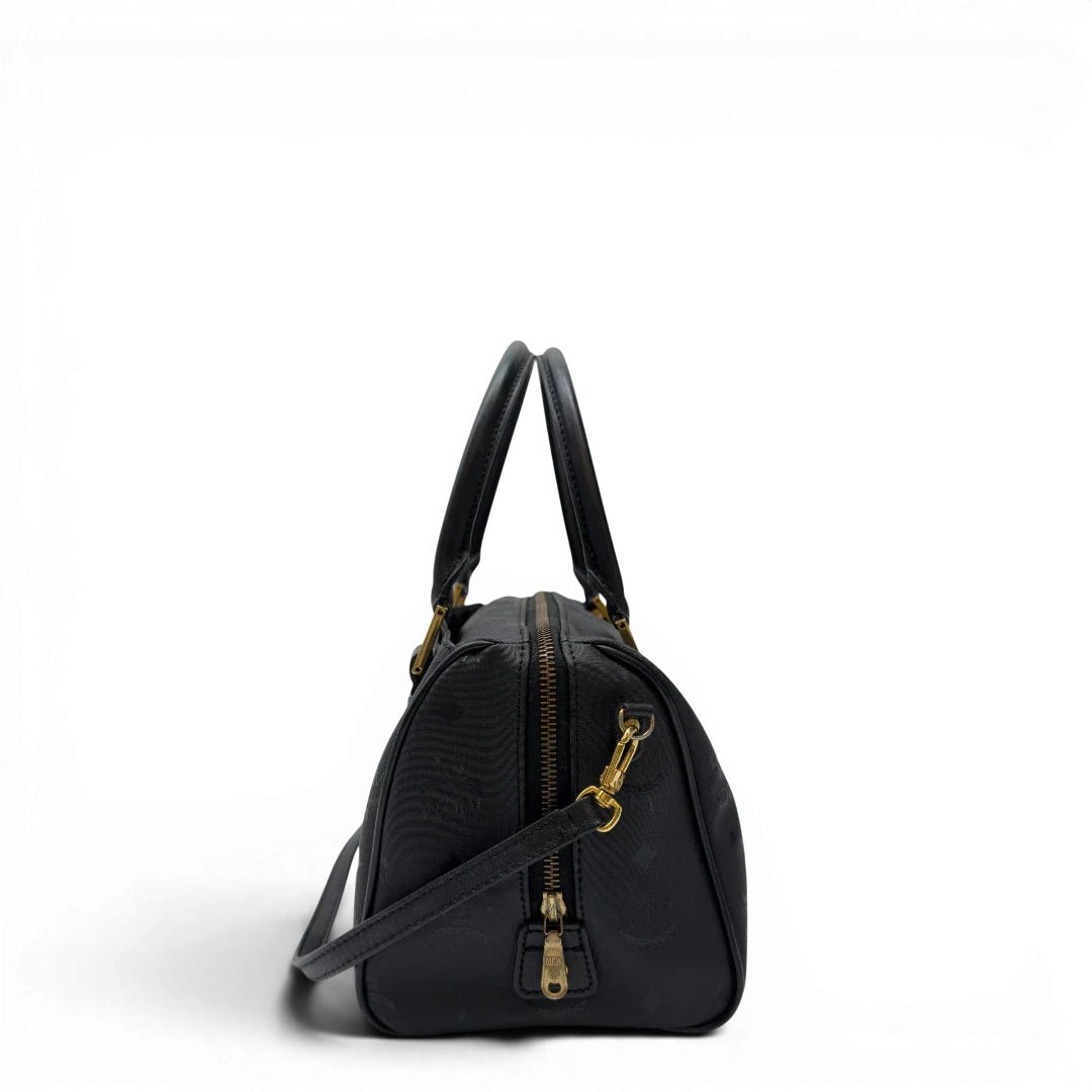https://cdn.shopify.com/s/files/1/0564/9376/8855/files/MCM_Handtasche_Boston_25_PVC_mit_Umhangegurt_schwarz_2.webp?v=1782983948