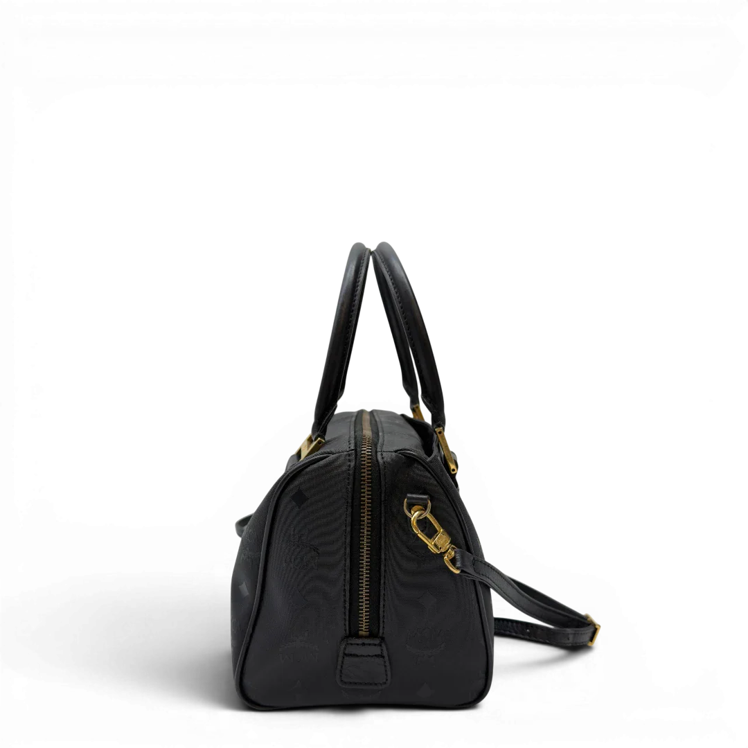 https://cdn.shopify.com/s/files/1/0564/9376/8855/files/MCM_Handtasche_Boston_25_PVC_mit_Umhangegurt_schwarz_3.webp?v=1782983948