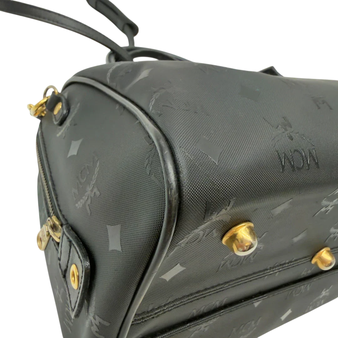 https://cdn.shopify.com/s/files/1/0564/9376/8855/files/MCM_Handtasche_Boston_25_PVC_mit_Umhangegurt_schwarz_6.webp?v=1782983949