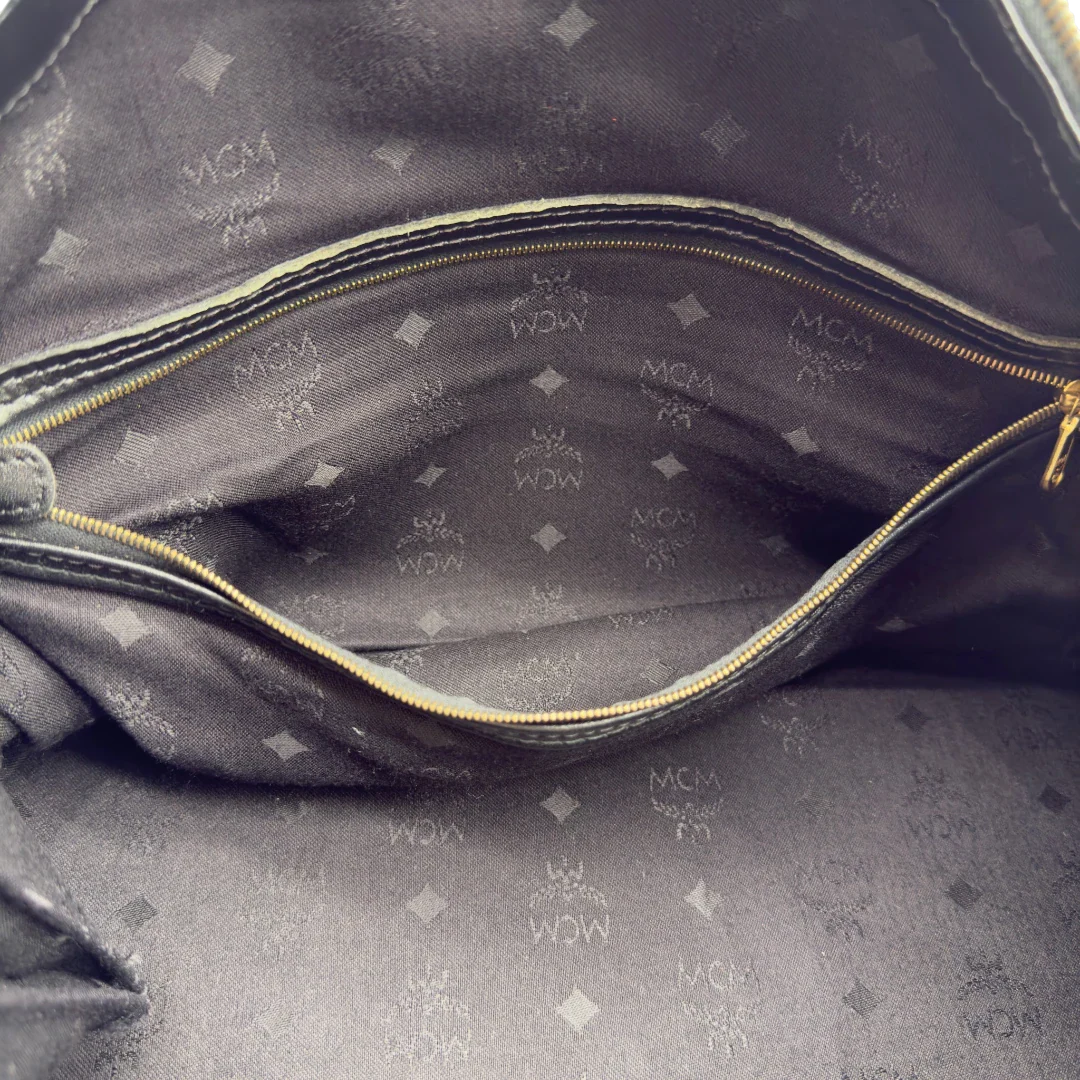 https://cdn.shopify.com/s/files/1/0564/9376/8855/files/MCM_Handtasche_Boston_35_vintage_mit_Umhangegurt_aus_PVC_schwarz_vintage7925.webp?v=1779969406