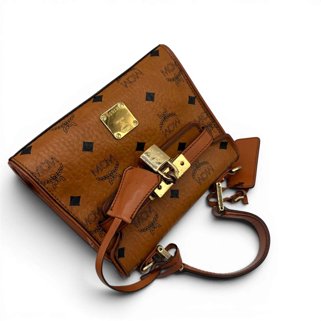 https://cdn.shopify.com/s/files/1/0564/9376/8855/files/MCM_Handtasche_Kelly_Style_mit_Umhangegurt_visetos_braun_13.webp?v=1781855176