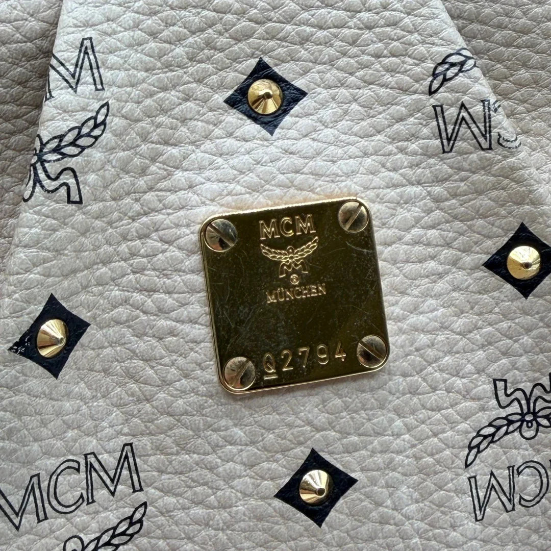 https://cdn.shopify.com/s/files/1/0564/9376/8855/files/MCM_Handtasche_mit_Nieten_mit_Umhangegurt_visetos_beige_10.webp?v=1781856231