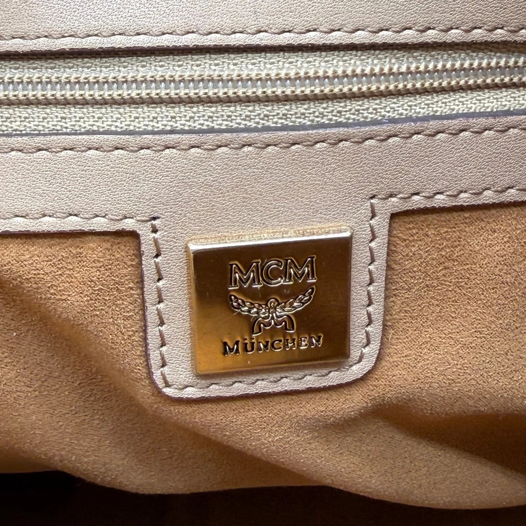 https://cdn.shopify.com/s/files/1/0564/9376/8855/files/MCM_Handtasche_mit_Nieten_mit_Umhangegurt_visetos_beige_15.webp?v=1781856231