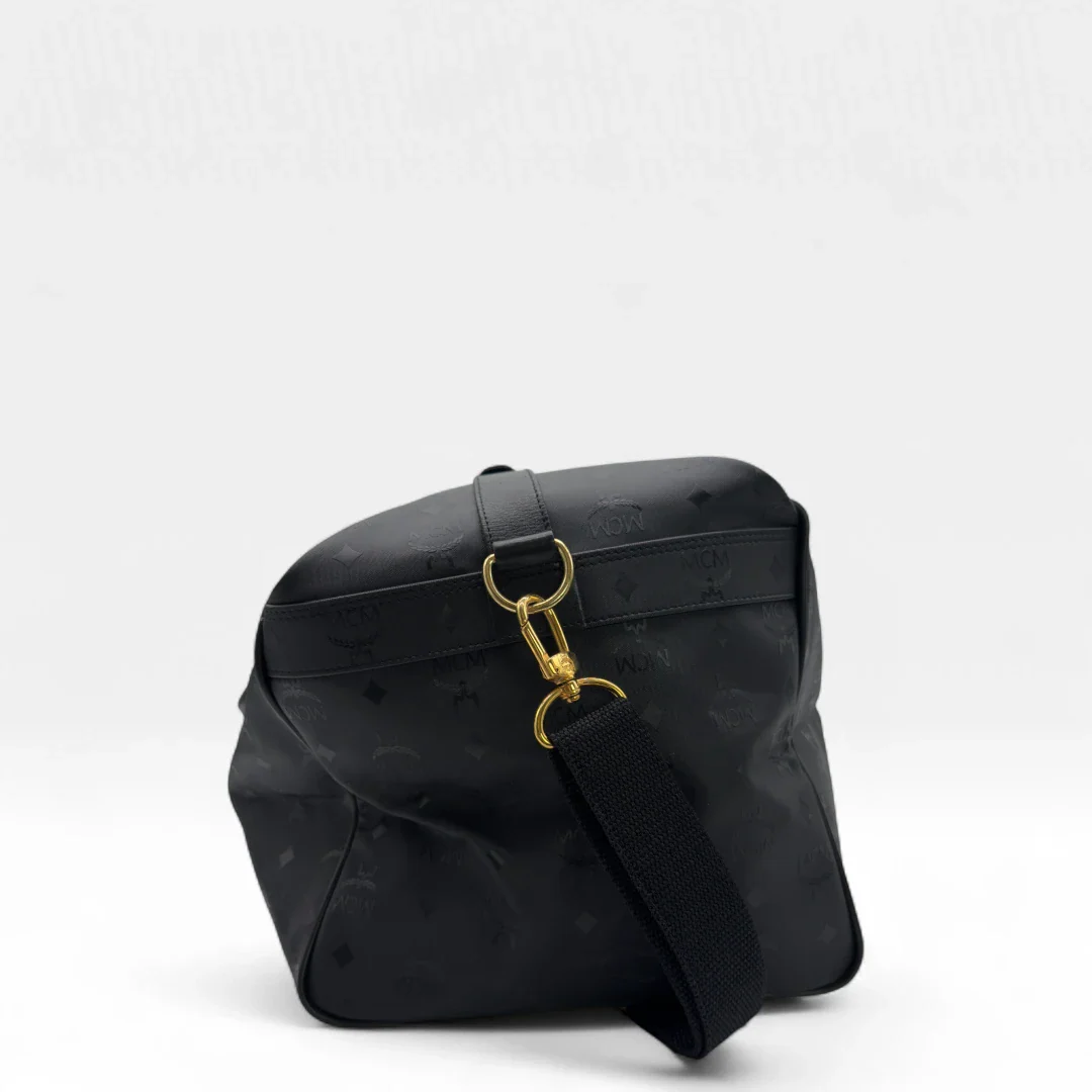 https://cdn.shopify.com/s/files/1/0564/9376/8855/files/MCM_Reisetasche_50_PVC_mit_Umhangegurt_monogram_schwarz_Vintage_luxury_MCM_Dufflebag4968.webp?v=1754500863