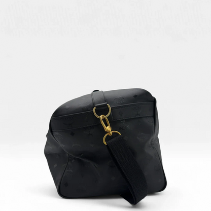 https://cdn.shopify.com/s/files/1/0564/9376/8855/files/MCM_Reisetasche_50_PVC_mit_Umhangegurt_monogram_schwarz_Vintage_luxury_MCM_Dufflebag4968.webp?v=1754500863