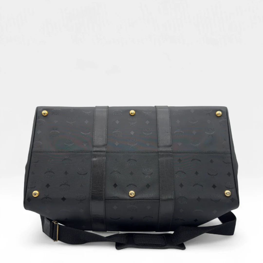 https://cdn.shopify.com/s/files/1/0564/9376/8855/files/MCM_Reisetasche_50_PVC_mit_Umhangegurt_monogram_schwarz_Vintage_luxury_MCM_Dufflebag4971.webp?v=1754500863