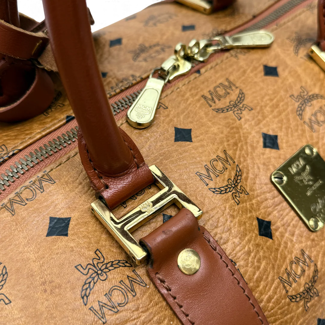 https://cdn.shopify.com/s/files/1/0564/9376/8855/files/MCM_Reisetasche_50_Zylinderform_visetos_braun_vintage_dufflebag4050.webp?v=1764296155