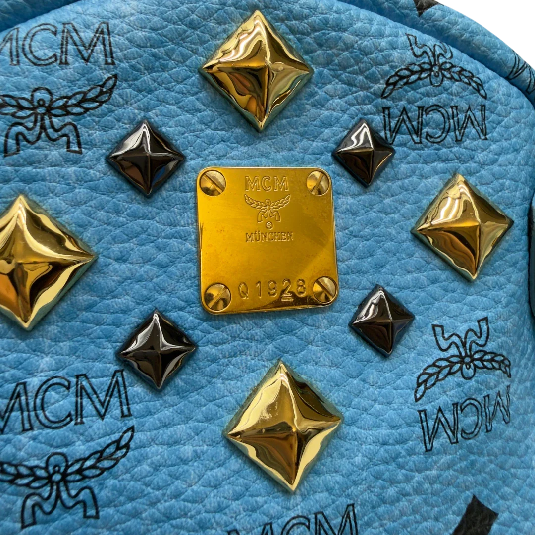 https://cdn.shopify.com/s/files/1/0564/9376/8855/files/MCM_Rucksack_Stark_mit_Nieten_medium_visetos_Munich_Blue_16.webp?v=1783514032