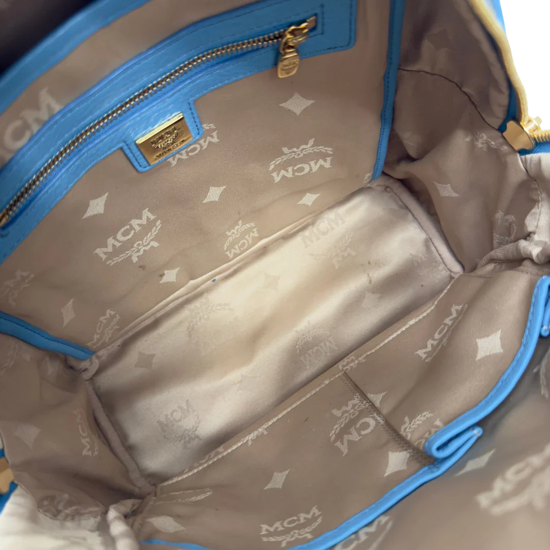 https://cdn.shopify.com/s/files/1/0564/9376/8855/files/MCM_Rucksack_Stark_mit_Nieten_medium_visetos_Munich_Blue_22.webp?v=1783514032