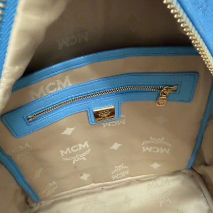 https://cdn.shopify.com/s/files/1/0564/9376/8855/files/MCM_Rucksack_Stark_mit_Nieten_medium_visetos_Munich_Blue_23.webp?v=1783514032