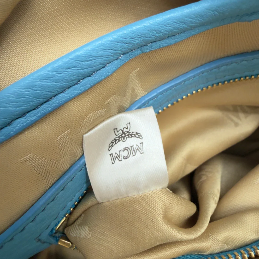https://cdn.shopify.com/s/files/1/0564/9376/8855/files/MCM_Rucksack_Stark_mit_Nieten_medium_visetos_Munich_Blue_25.webp?v=1783514032