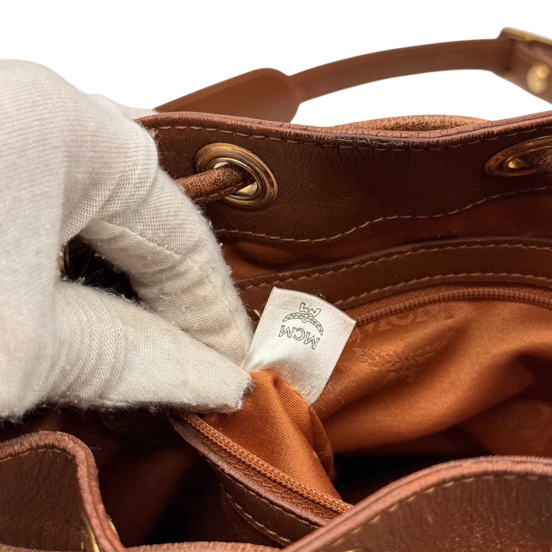 https://cdn.shopify.com/s/files/1/0564/9376/8855/files/MCM_Umhangetasche_Beuteltasche_small_mit_Kordelzug_visetos_braun_27.webp?v=1784795648