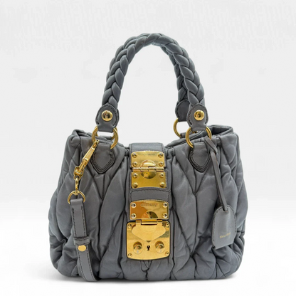 https://cdn.shopify.com/s/files/1/0564/9376/8855/files/Miu_Miu_Handtasche_Matellasse_aus_Leder_grau8369.webp?v=1757509271
