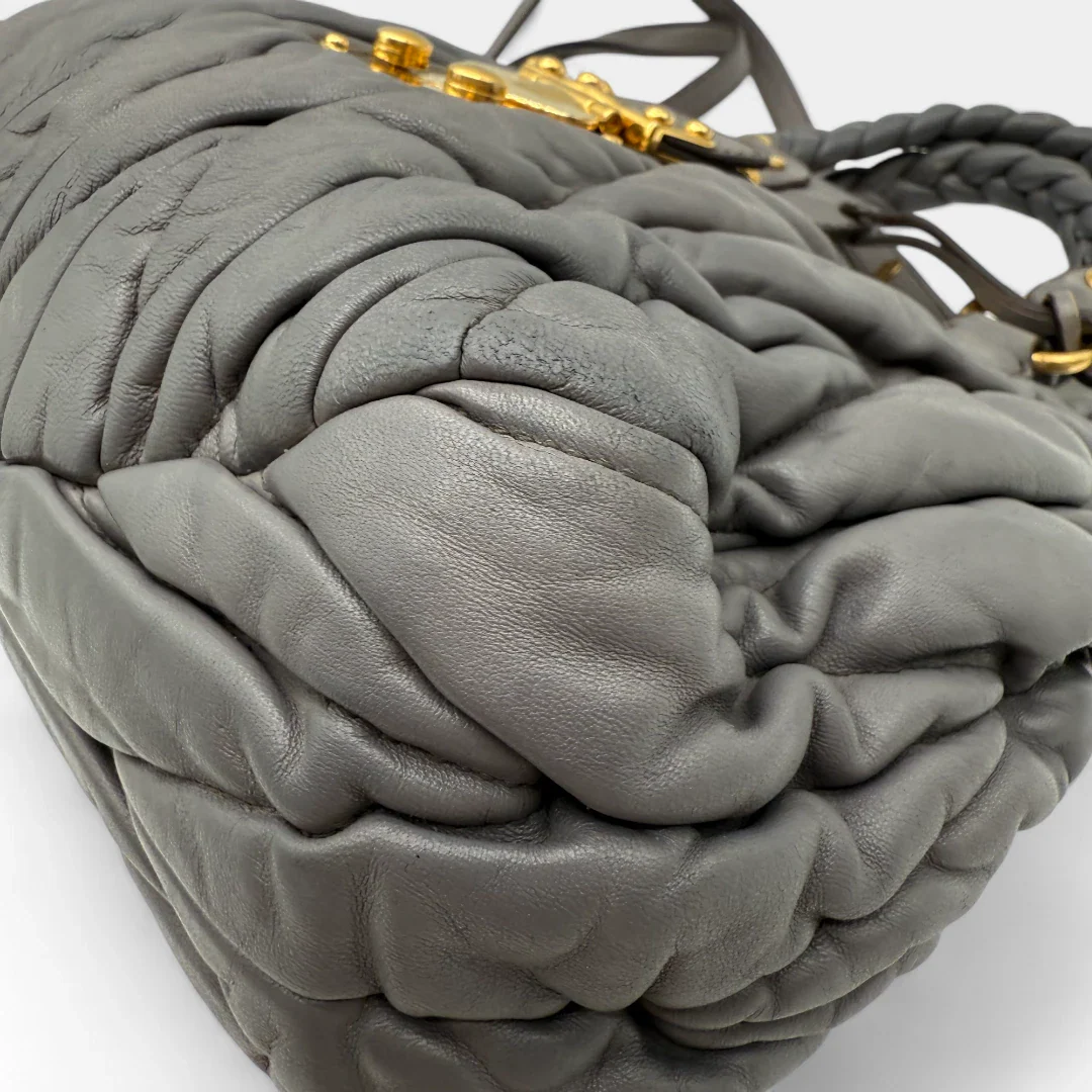 https://cdn.shopify.com/s/files/1/0564/9376/8855/files/Miu_Miu_Handtasche_Matellasse_aus_Leder_grau8375.webp?v=1757509205