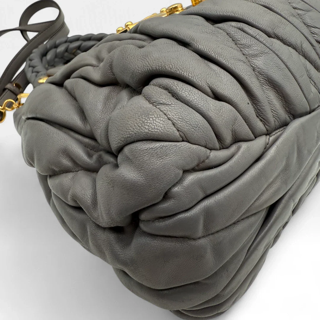 https://cdn.shopify.com/s/files/1/0564/9376/8855/files/Miu_Miu_Handtasche_Matellasse_aus_Leder_grau8376.webp?v=1757509205