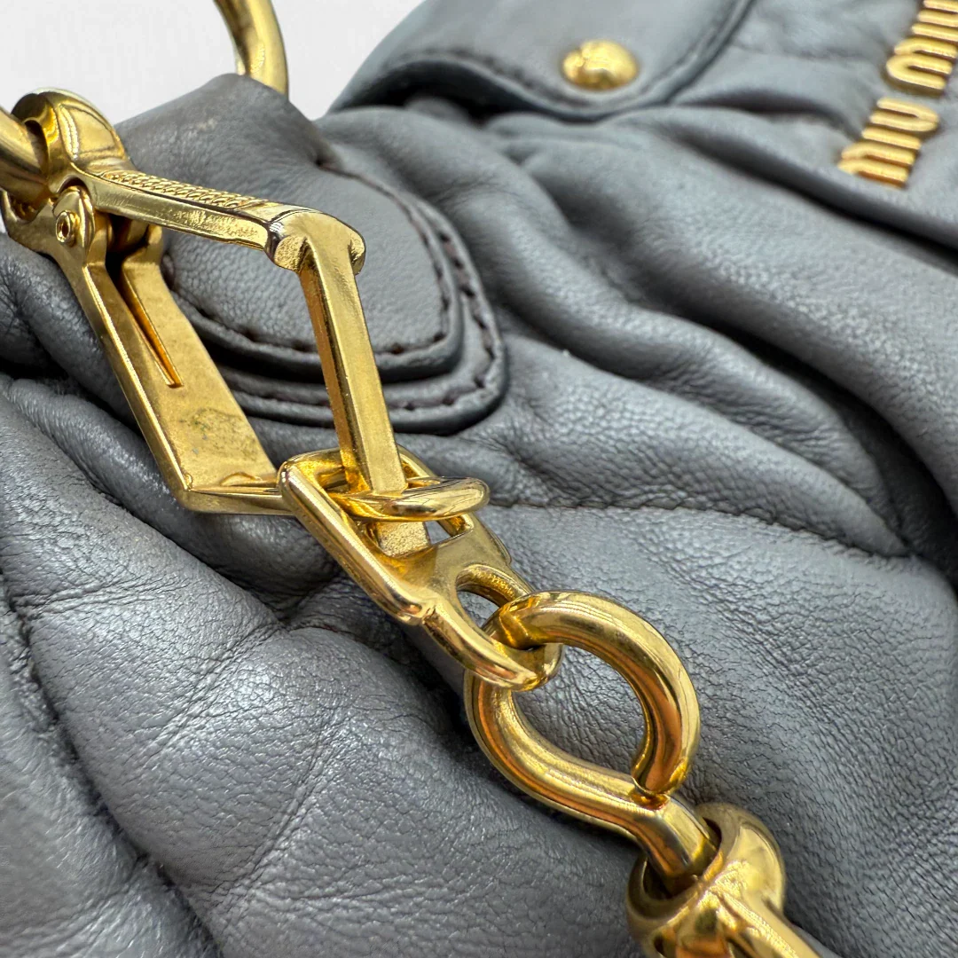 https://cdn.shopify.com/s/files/1/0564/9376/8855/files/Miu_Miu_Handtasche_Matellasse_aus_Leder_grau8380.webp?v=1757509204