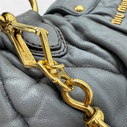 https://cdn.shopify.com/s/files/1/0564/9376/8855/files/Miu_Miu_Handtasche_Matellasse_aus_Leder_grau8380.webp?v=1757509204