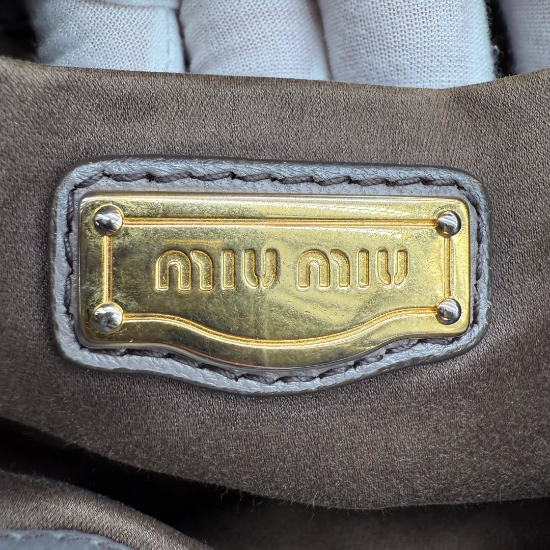 https://cdn.shopify.com/s/files/1/0564/9376/8855/files/Miu_Miu_Handtasche_Matellasse_aus_Leder_grau8383.webp?v=1757509204