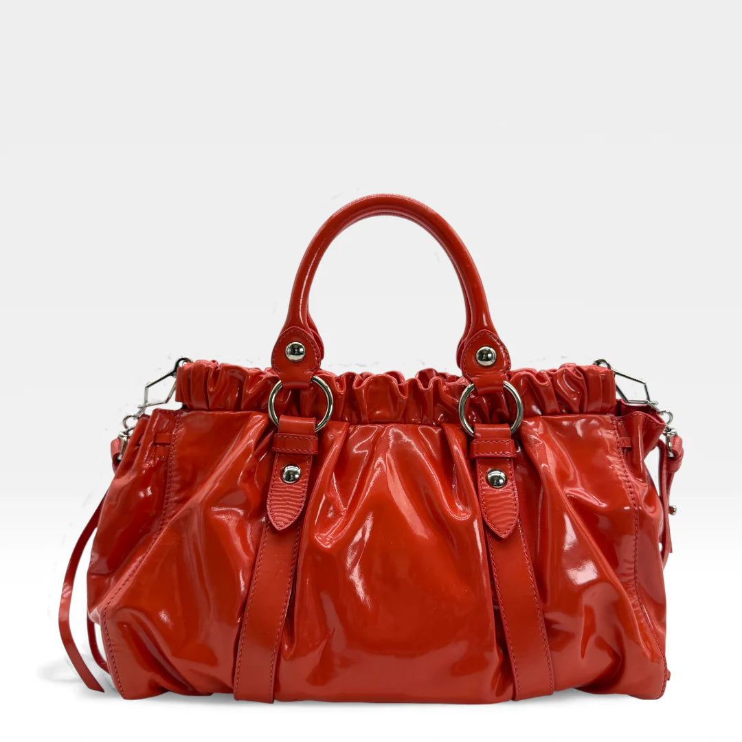 https://cdn.shopify.com/s/files/1/0564/9376/8855/files/Miu_Miu_Handtasche_Vitello_Lux_aus_Lackleder_rot_vintage_handbag_4563.webp?v=1765401273