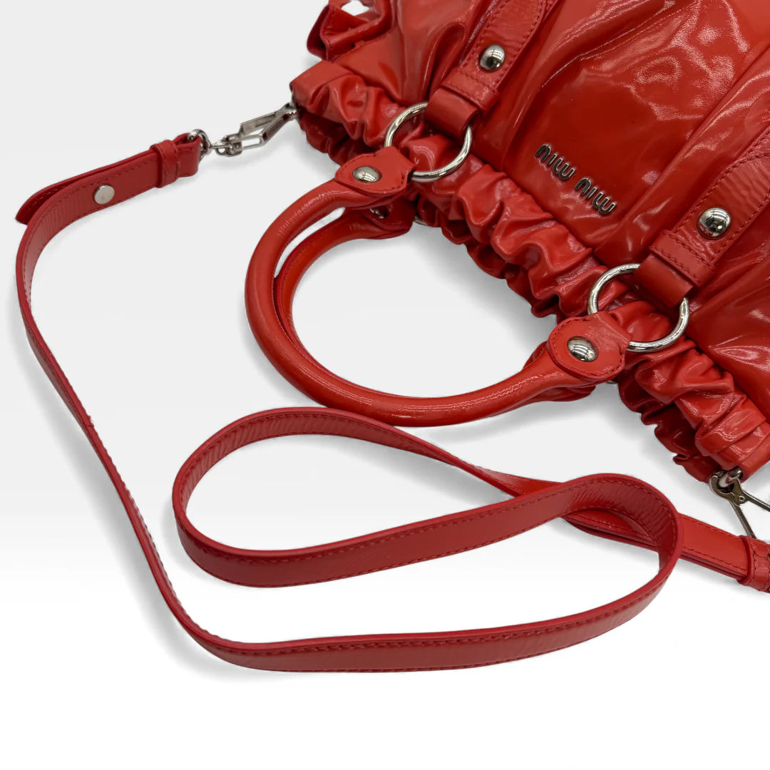 https://cdn.shopify.com/s/files/1/0564/9376/8855/files/Miu_Miu_Handtasche_Vitello_Lux_aus_Lackleder_rot_vintage_handbag_4573.webp?v=1765401274