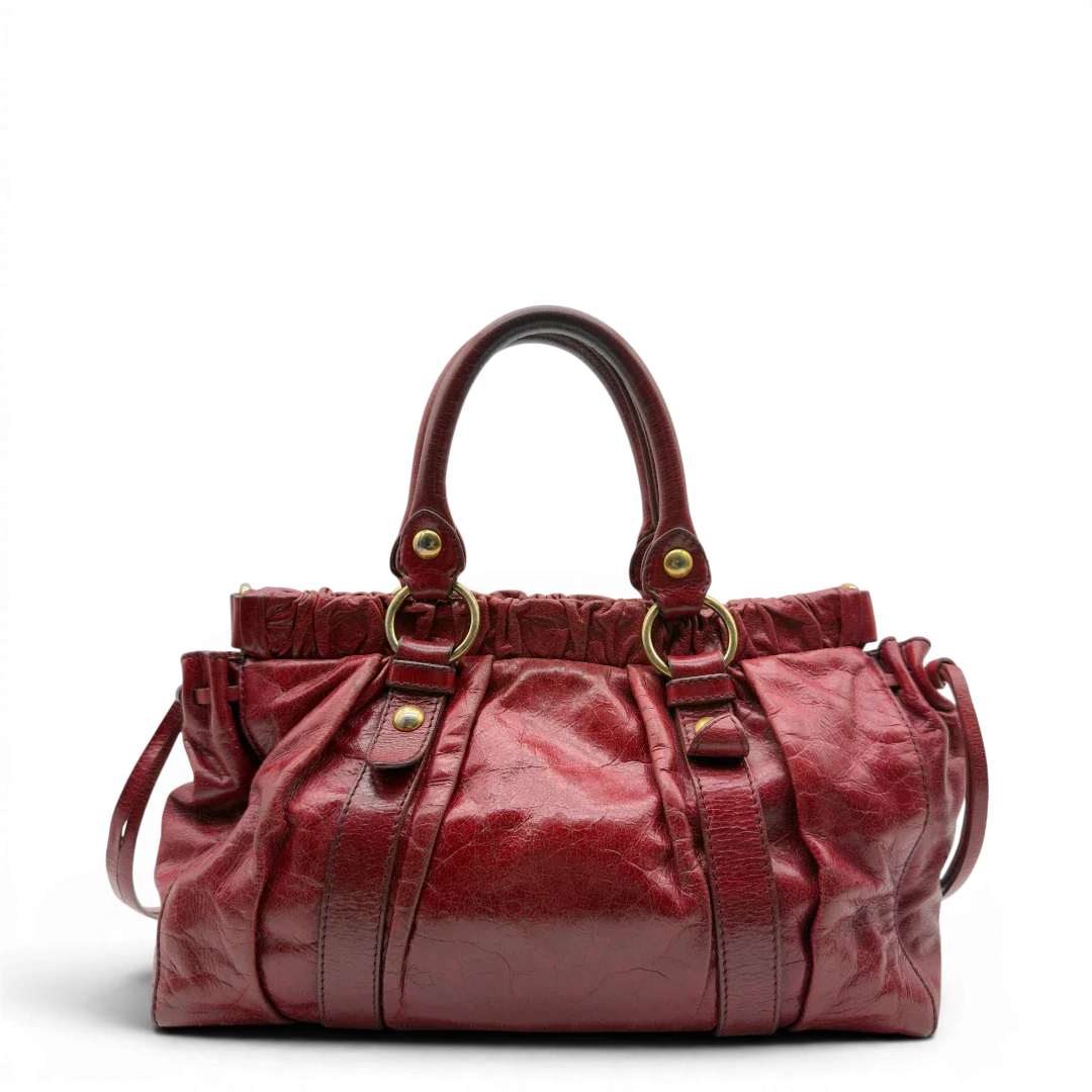 https://cdn.shopify.com/s/files/1/0564/9376/8855/files/Miu_Miu_Handtasche_Vitello_Lux_aus_Leder_dunkelrot_vintage7256.webp?v=1778681884