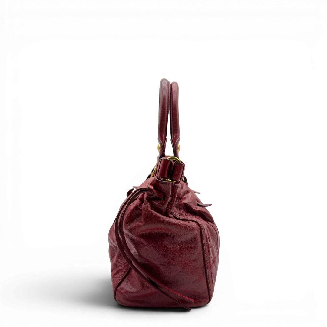 https://cdn.shopify.com/s/files/1/0564/9376/8855/files/Miu_Miu_Handtasche_Vitello_Lux_aus_Leder_dunkelrot_vintage7258.webp?v=1778681884