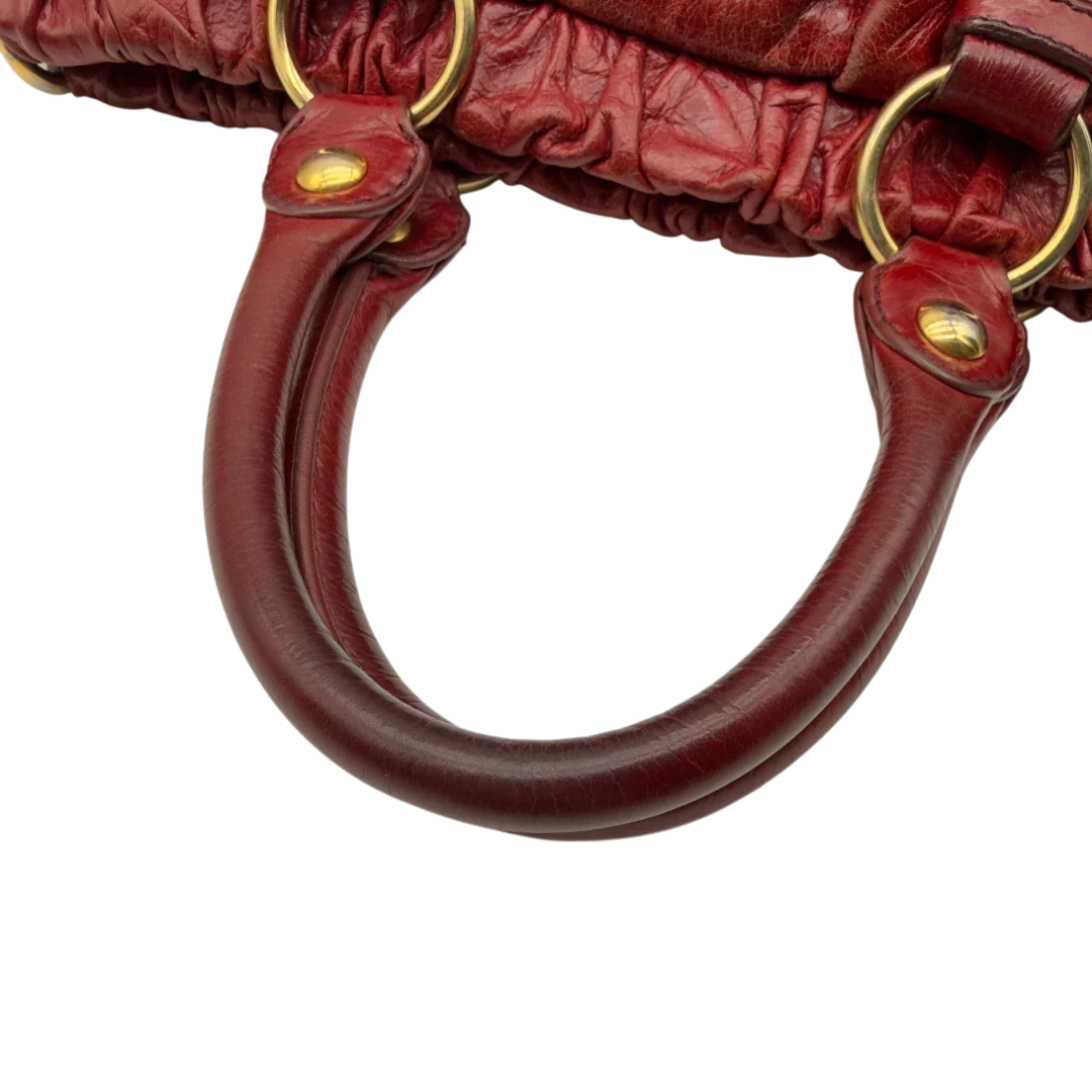 https://cdn.shopify.com/s/files/1/0564/9376/8855/files/Miu_Miu_Handtasche_Vitello_Lux_aus_Leder_dunkelrot_vintage7264.webp?v=1778681884