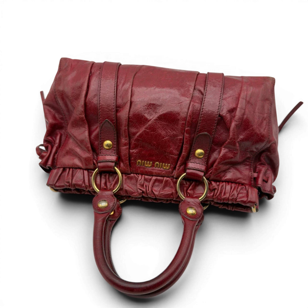 https://cdn.shopify.com/s/files/1/0564/9376/8855/files/Miu_Miu_Handtasche_Vitello_Lux_aus_Leder_dunkelrot_vintage7265.webp?v=1778681884
