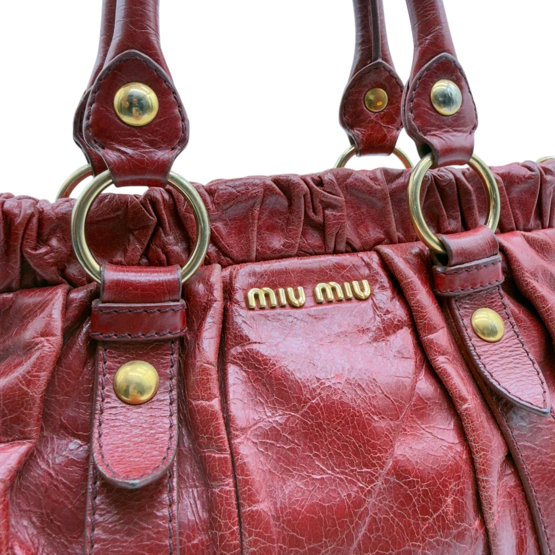 https://cdn.shopify.com/s/files/1/0564/9376/8855/files/Miu_Miu_Handtasche_Vitello_Lux_aus_Leder_dunkelrot_vintage7266.webp?v=1778681884