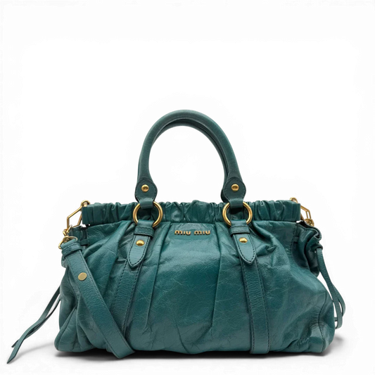 https://cdn.shopify.com/s/files/1/0564/9376/8855/files/Miu_Miu_Handtasche_Vitello_Lux_mit_Umhangegurt_Leder_blau_turkis_vintage4469.webp?v=1775728339