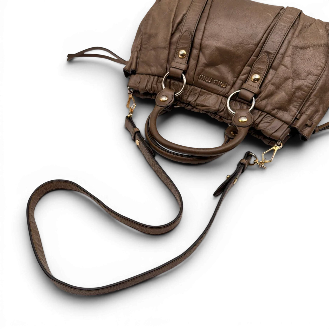 https://cdn.shopify.com/s/files/1/0564/9376/8855/files/Miu_Miu_Handtasche_Vitello_Lux_mit_Umhangegurt_aus_Leder_beige_13.webp?v=1784794035