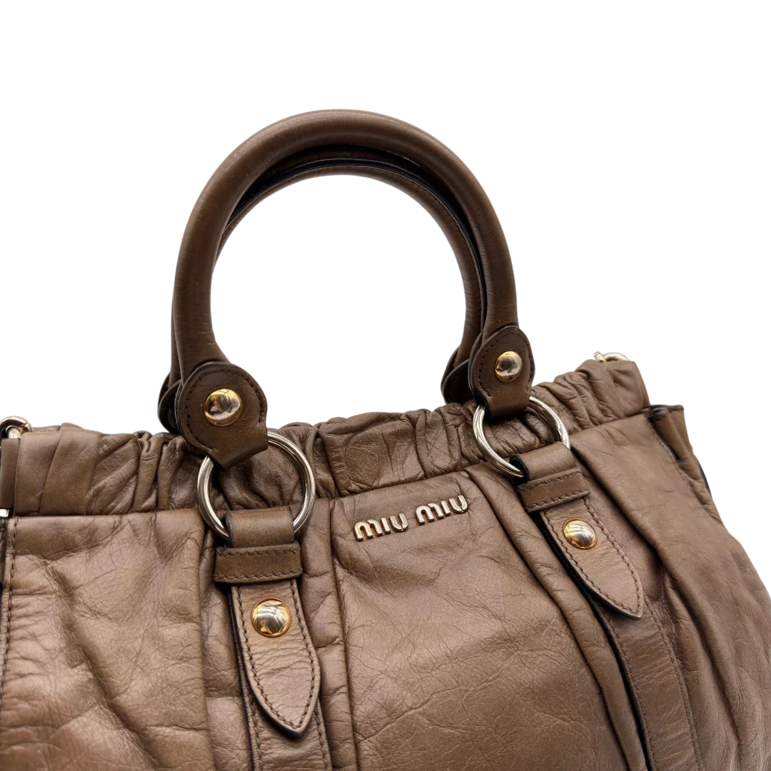 https://cdn.shopify.com/s/files/1/0564/9376/8855/files/Miu_Miu_Handtasche_Vitello_Lux_mit_Umhangegurt_aus_Leder_beige_15.webp?v=1784794035