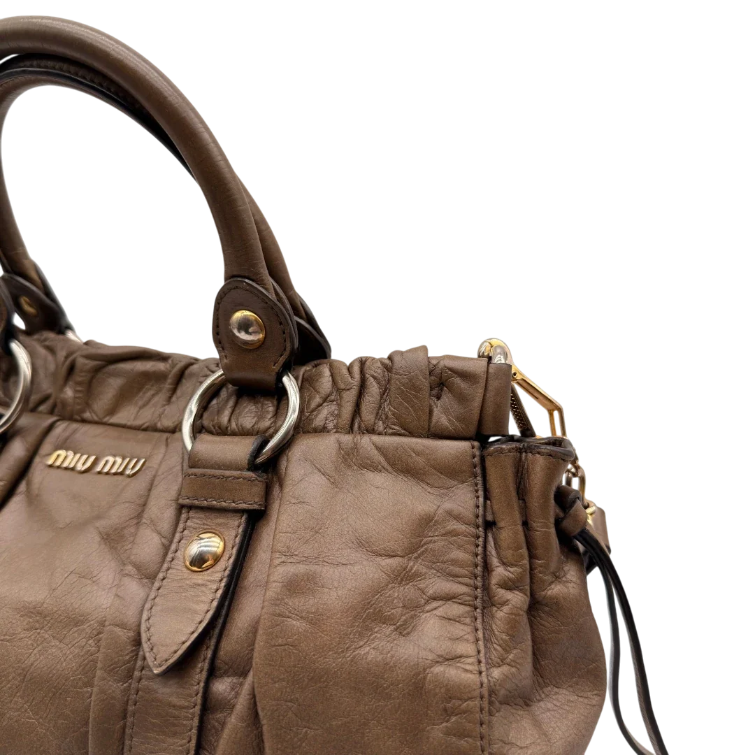 https://cdn.shopify.com/s/files/1/0564/9376/8855/files/Miu_Miu_Handtasche_Vitello_Lux_mit_Umhangegurt_aus_Leder_beige_16.webp?v=1784794035