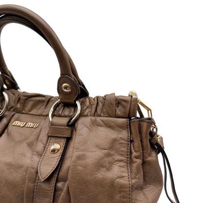 https://cdn.shopify.com/s/files/1/0564/9376/8855/files/Miu_Miu_Handtasche_Vitello_Lux_mit_Umhangegurt_aus_Leder_beige_16.webp?v=1784794035