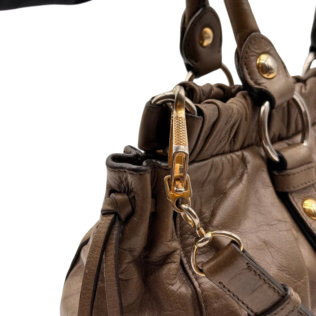 https://cdn.shopify.com/s/files/1/0564/9376/8855/files/Miu_Miu_Handtasche_Vitello_Lux_mit_Umhangegurt_aus_Leder_beige_17.webp?v=1784794035