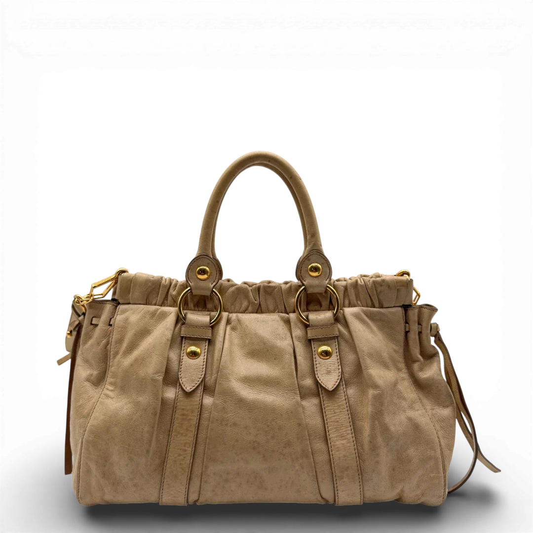 https://cdn.shopify.com/s/files/1/0564/9376/8855/files/Miu_Miu_Handtasche_Vitello_Lux_mit_Umhangegurt_aus_Leder_beige_vintage2516.webp?v=1773321026