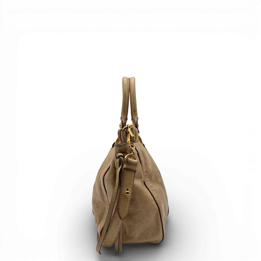 https://cdn.shopify.com/s/files/1/0564/9376/8855/files/Miu_Miu_Handtasche_Vitello_Lux_mit_Umhangegurt_aus_Leder_beige_vintage2518.webp?v=1773321025