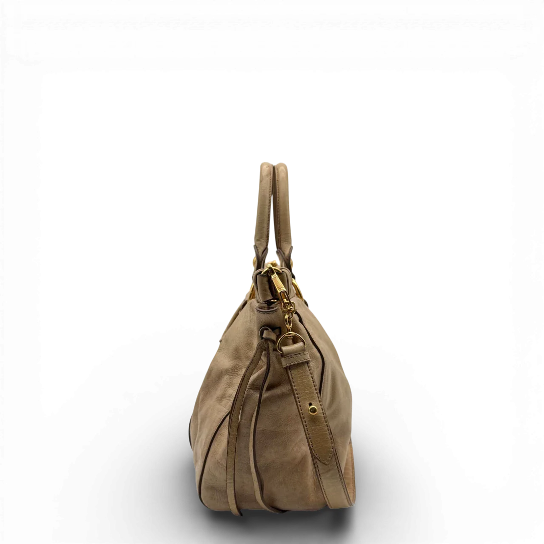 https://cdn.shopify.com/s/files/1/0564/9376/8855/files/Miu_Miu_Handtasche_Vitello_Lux_mit_Umhangegurt_aus_Leder_beige_vintage2519.webp?v=1773321026