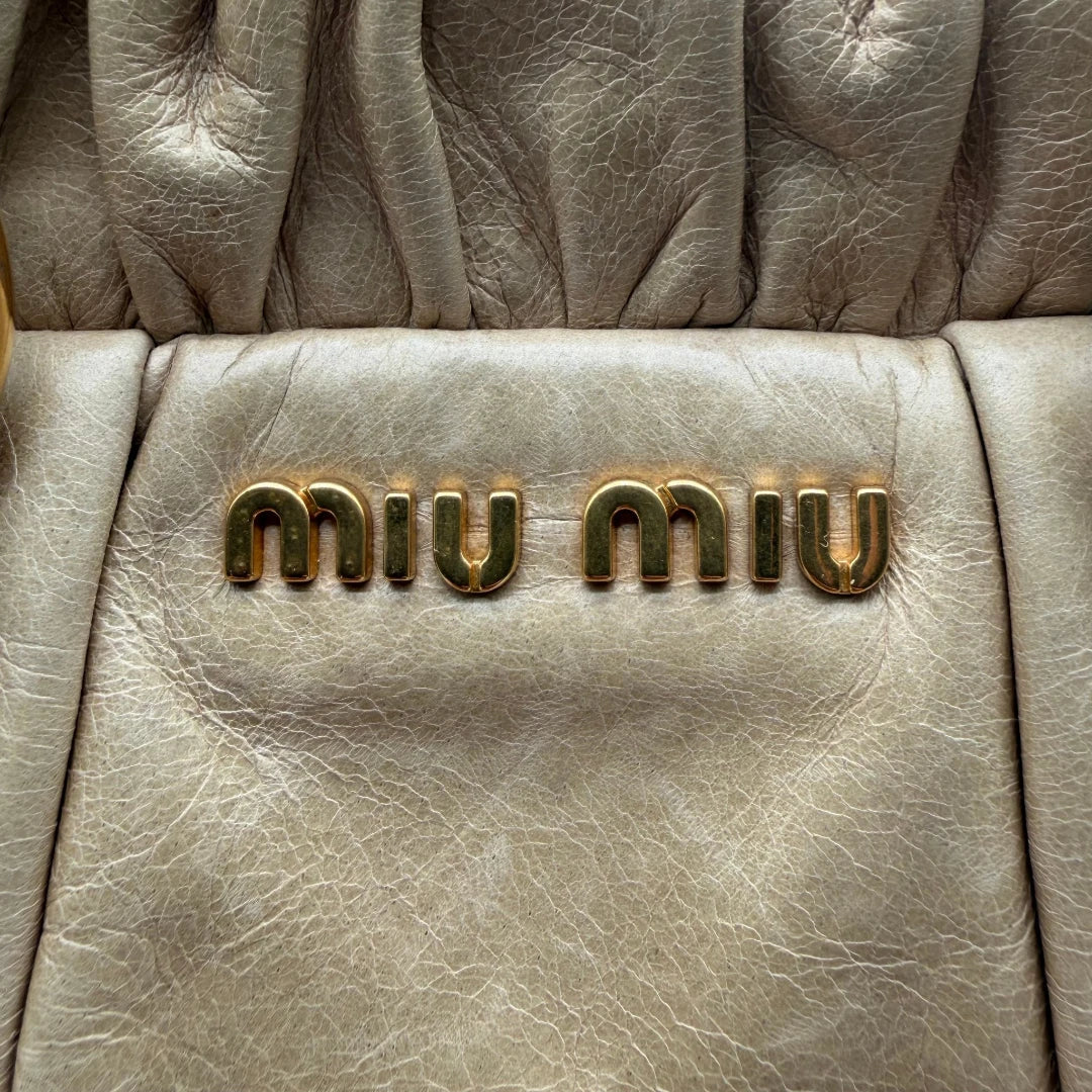 https://cdn.shopify.com/s/files/1/0564/9376/8855/files/Miu_Miu_Handtasche_Vitello_Lux_mit_Umhangegurt_aus_Leder_beige_vintage2528.webp?v=1773321026