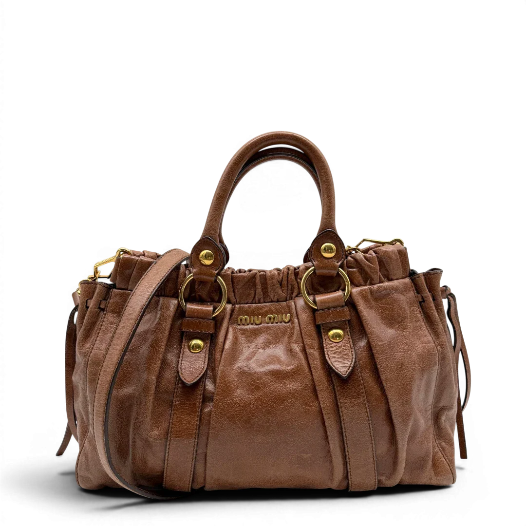 https://cdn.shopify.com/s/files/1/0564/9376/8855/files/Miu_Miu_Handtasche_Vitello_Lux_mit_Umhangegurt_aus_Leder_braun_vintage6492.webp?v=1778682434
