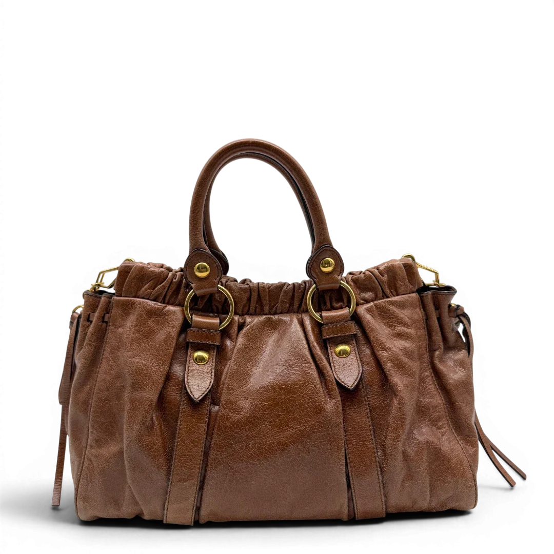 https://cdn.shopify.com/s/files/1/0564/9376/8855/files/Miu_Miu_Handtasche_Vitello_Lux_mit_Umhangegurt_aus_Leder_braun_vintage6493.webp?v=1778682434
