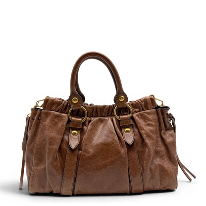 https://cdn.shopify.com/s/files/1/0564/9376/8855/files/Miu_Miu_Handtasche_Vitello_Lux_mit_Umhangegurt_aus_Leder_braun_vintage6493.webp?v=1778682434